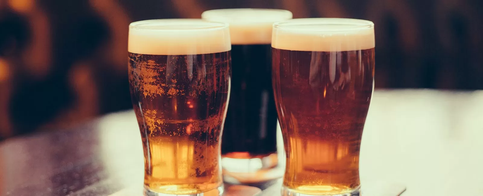 Glasses of light and dark beer on a pub background.